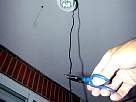 Bricolaje de electricidad - instalar un sensor de movimiento - foto cortando el cable negro con las tijeras de electricista