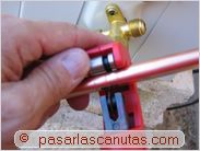 instalar aire acondicionado split - cortando el tubo de cobre grueso por la parte que va a la unidad exterior de aire acondicionado split