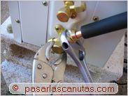 instalar aire acondicionado split - apretando la union del tubo de cobre grueso a la unidad exterior de aire acondicionado split