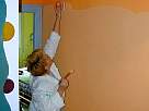 foto pintando una pared de color naranja