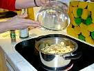 foto de los trozos de manzana para hacer la compota puestos en un recipiente al fuego en la cocina vitroceramica
