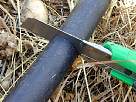 foto cortando el tubo de polietileno para instalar riego por goteo subterr�neo en nuestro huerto familiar